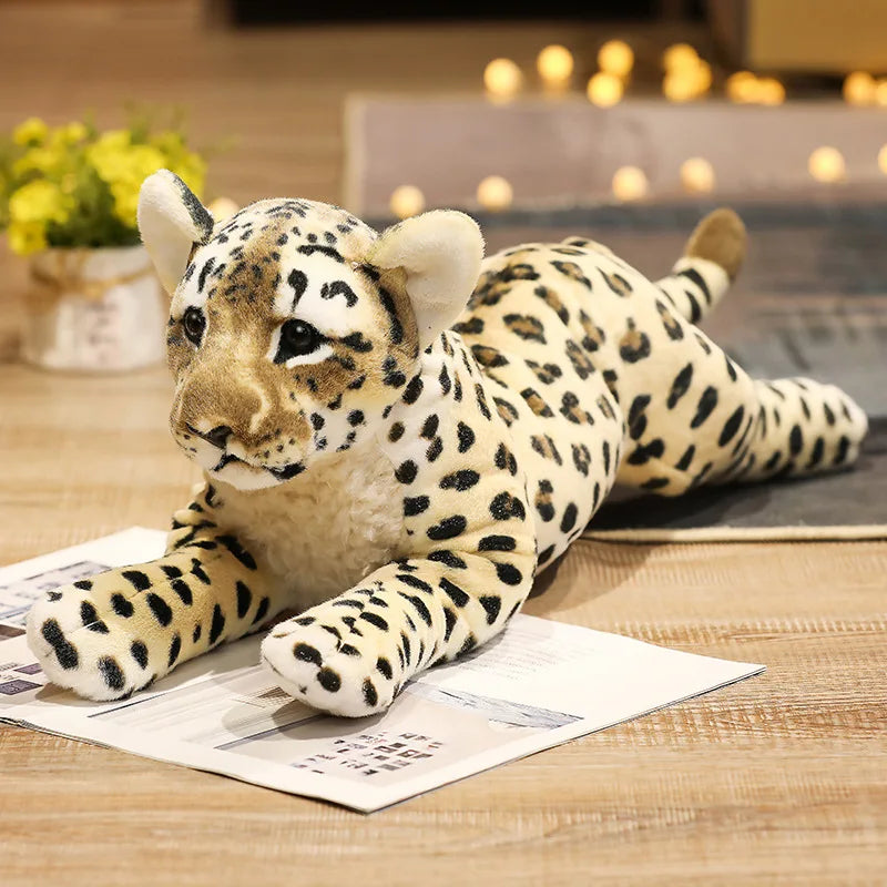 Realistic lion cub stuffed animal next to safari decor props on a wooden shelf