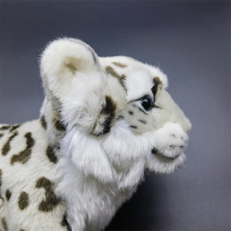 Realistic snow leopard plush size comparison next to hand