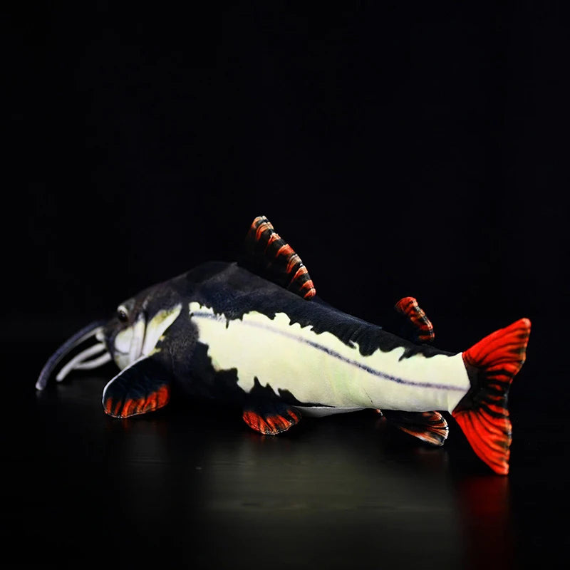 Redtail catfish plush side profile showing vibrant crimson tail fin