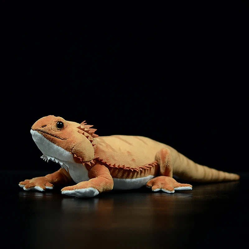 Reptile stuffed animal bearded dragon displayed on wooden shelf with decor