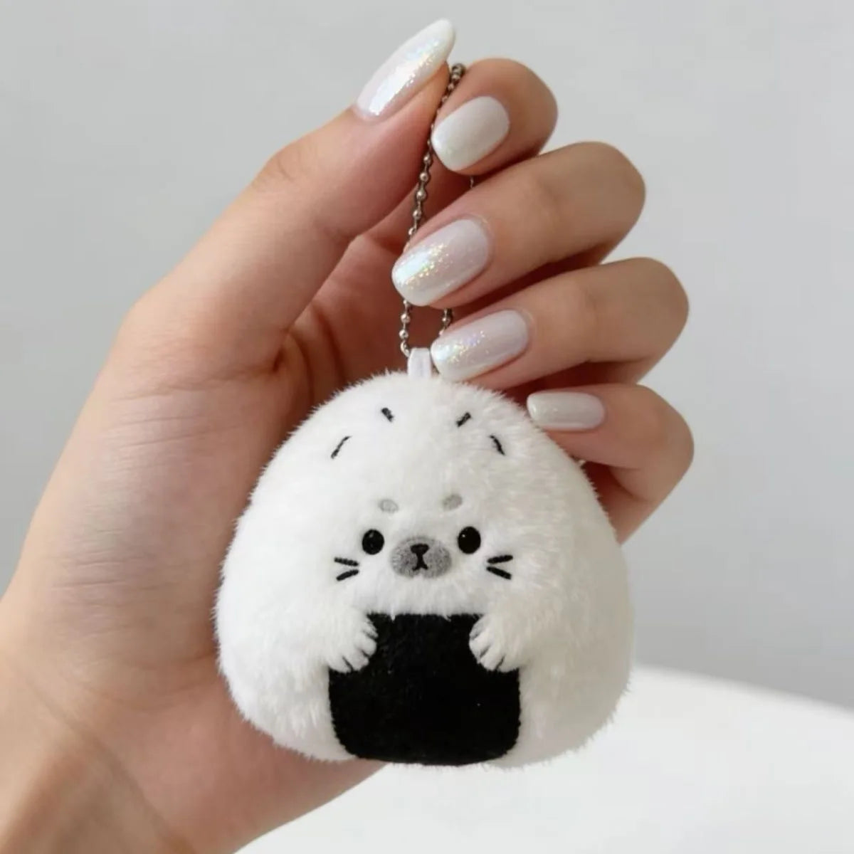 Rice ball toy plushie sitting beside a laptop as desk decoration