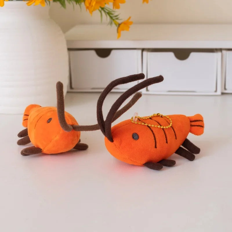 Shrimp handmade plushie keychain next to a hand for size reference