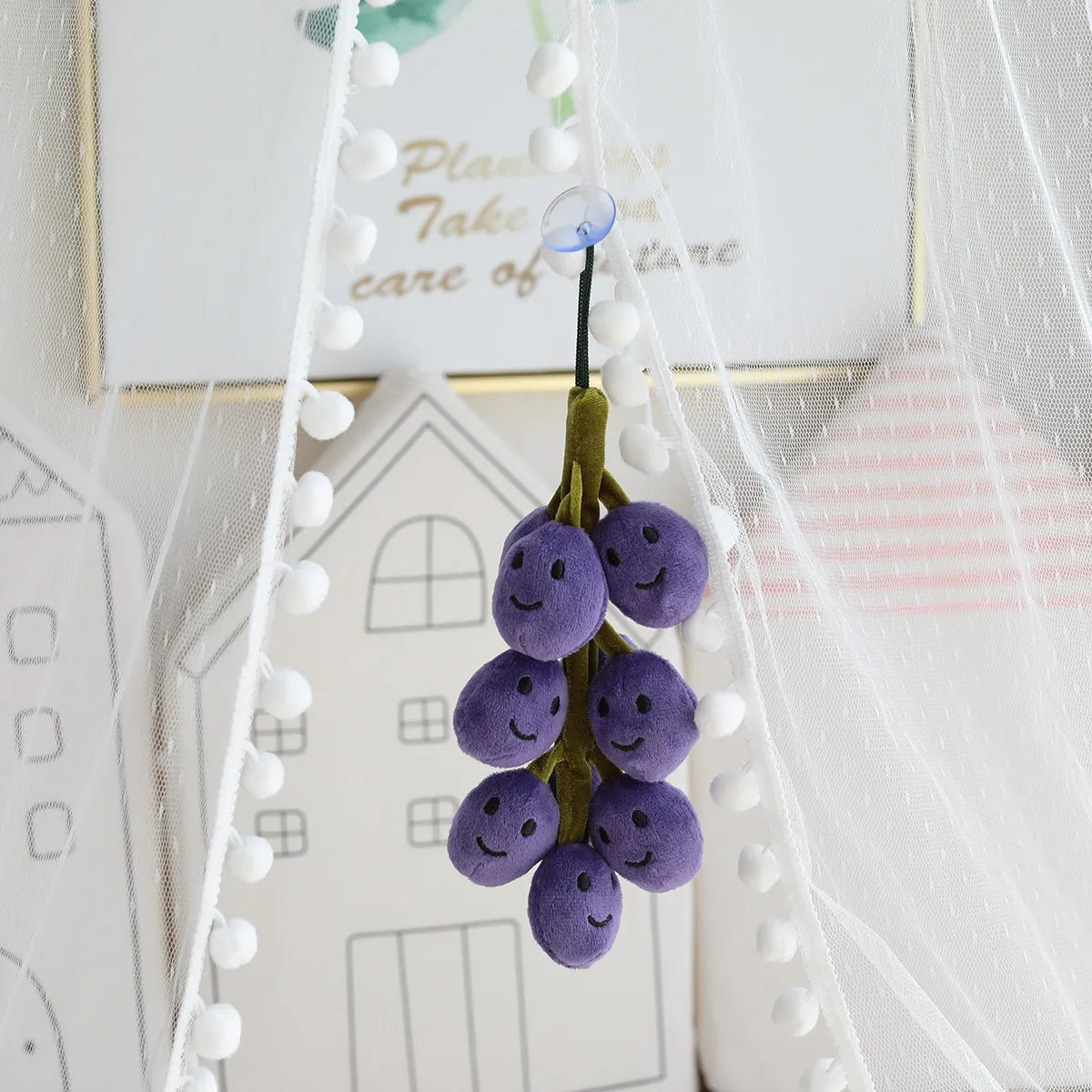 Small green smiling grapes plush 20cm sitting on pastel pink shelf next to kawaii plush collectibles