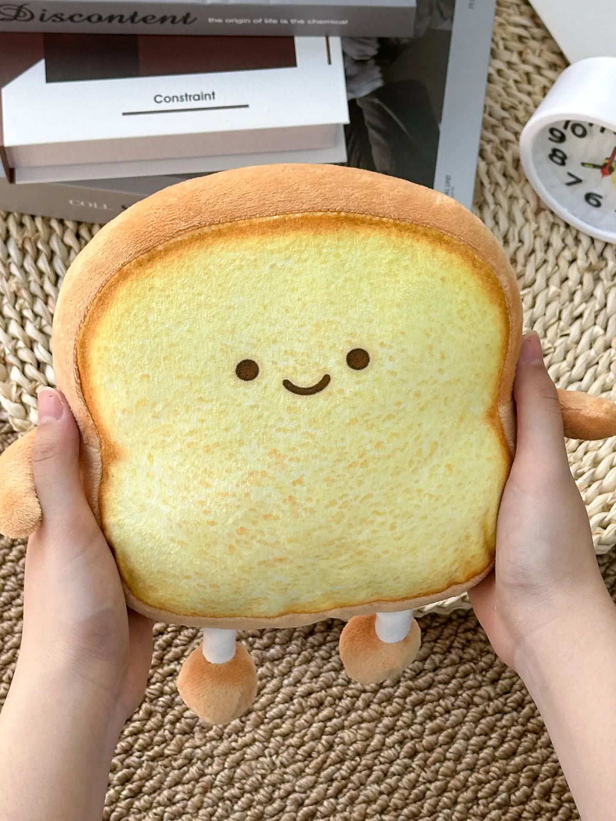 Smiling bread plushie used as kawaii desk buddy beside a laptop