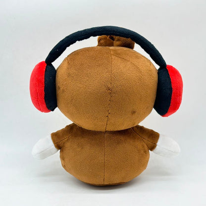 Soft handmade monkey plush toy with red headphones top down view