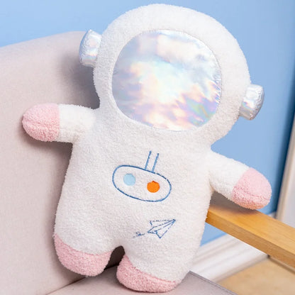 Space nursery decor arrangement featuring astronaut plush toy and rocket plushie on shelf