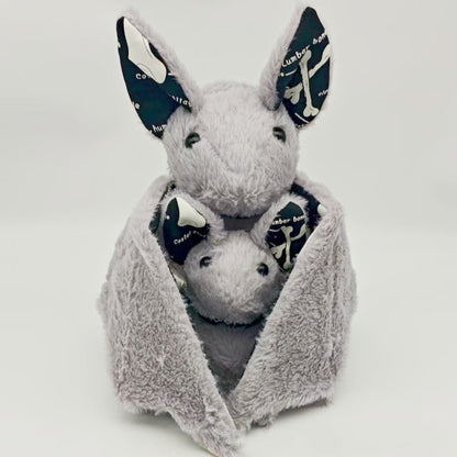 Spooky plush toy bat sitting upright with wings spread