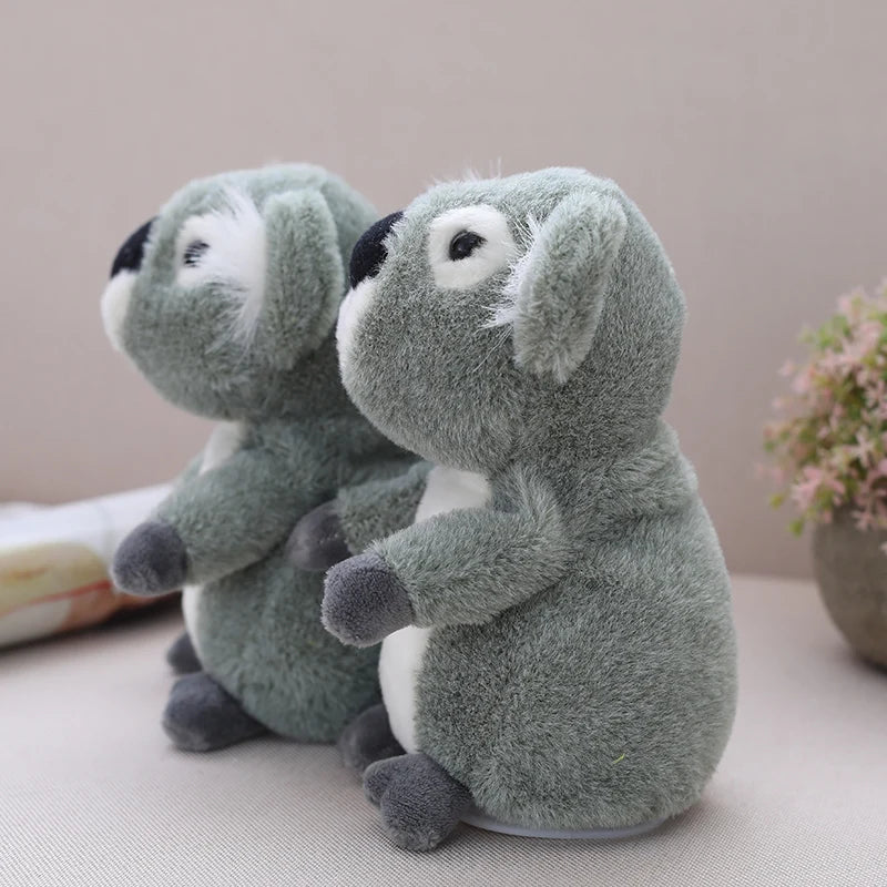 Talking koala plush toy shown next to a hand for size reference at 18cm