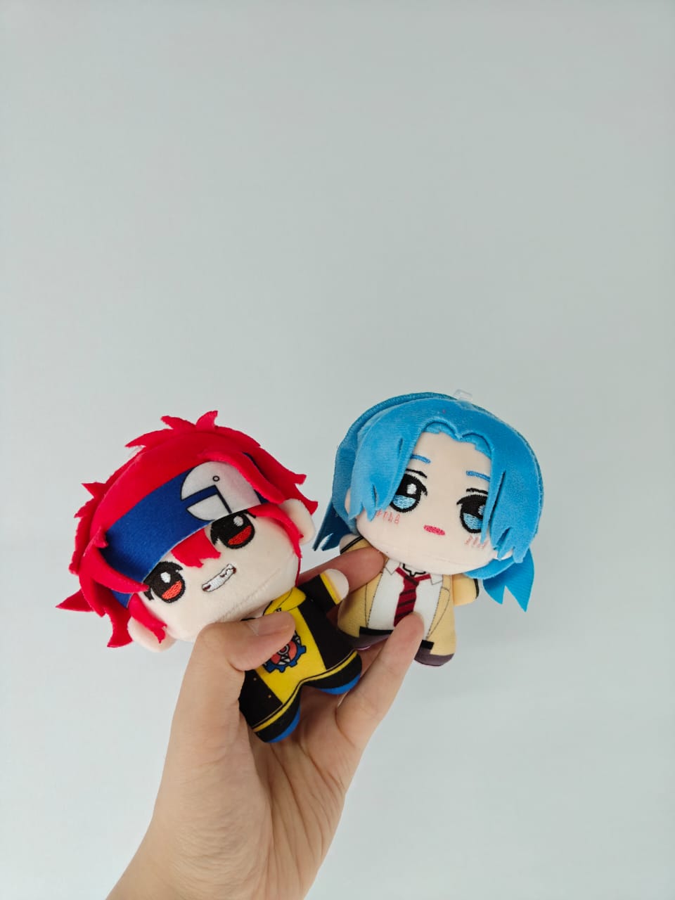 The 10cm plush toy placed on a desk to demonstrate its compact display size.