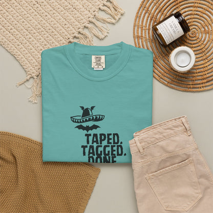 The Midnight Mariachi graphic tee hanging on wooden hanger against concrete wall background
