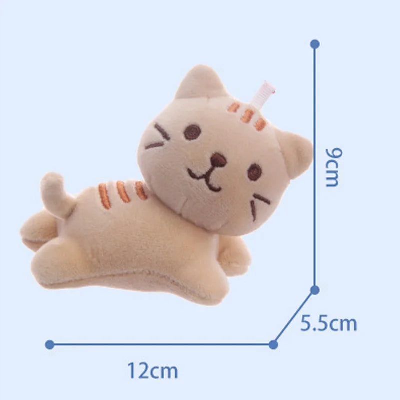 Tilt-head kitten backpack charm attached to black backpack zipper
