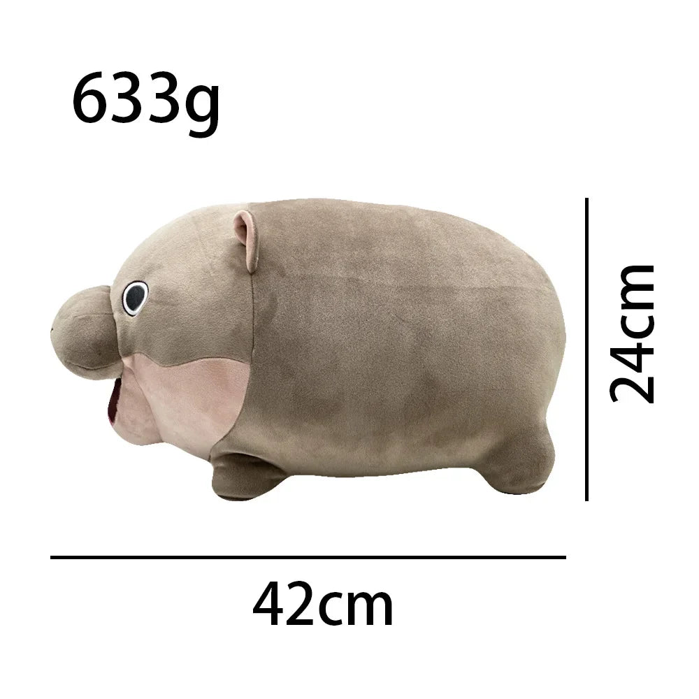 Top-down view of Moo Deng hippo stuffed animal, gray plush surface and small ear details visible
