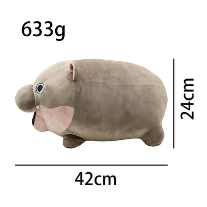 Top-down view of Moo Deng hippo stuffed animal, gray plush surface and small ear details visible
