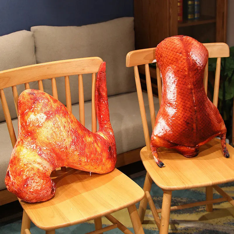 Two glossy roasted duck-shaped decorative objects displayed on wooden chairs in a living room setting.