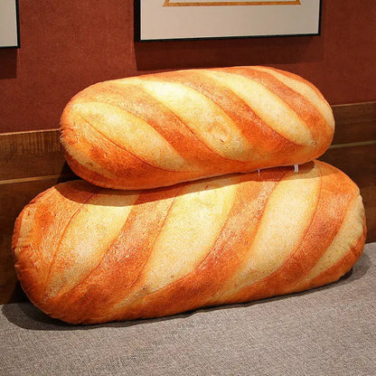 Two large bread-shaped cushions on a textured surface with a framed picture in the background.