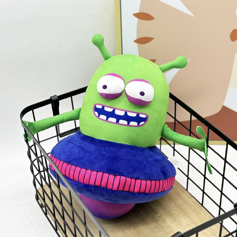 UFO alien plush toy displayed on gaming shelf next to controller
