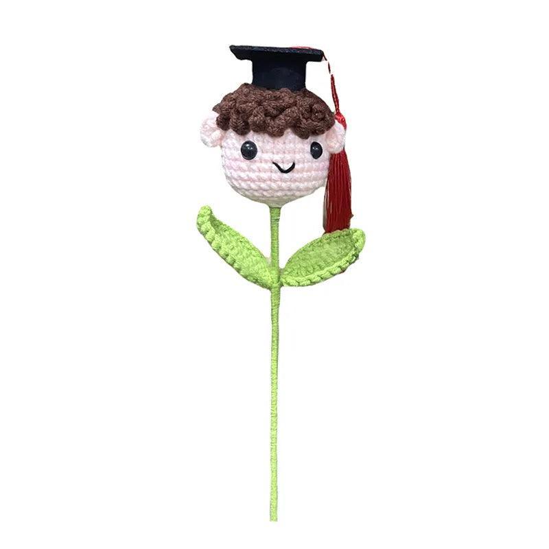 Yarn flower doll displayed as part of a crochet graduation bouquet arrangement
